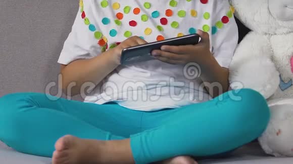 小男孩在玩具熊旁边的智能手机上画画日常生活中的电子产品视频的预览图