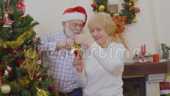 幸福的老夫妇装饰圣诞树视频的预览图