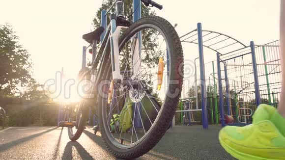 女运动员坐在自行车上他离开了某个地方详细的踏板和车轮日落时骑自行车视频的预览图