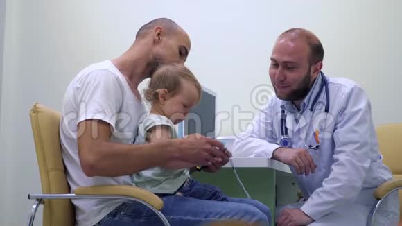年轻的父亲带着小女儿参加儿科医生会诊视频的预览图