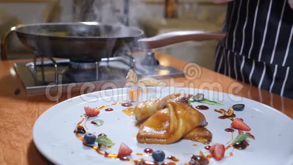 提供食物一个厨师的特写在一个盘子上提供弗拉姆风格的煎饼上面装饰着浆果和水果餐厅视频的预览图