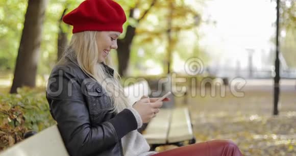 戴贝雷帽的快乐女人用智能手机视频的预览图