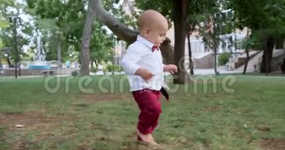 可爱的宝宝在户外公园的草地上赤脚迈出第一步视频的预览图
