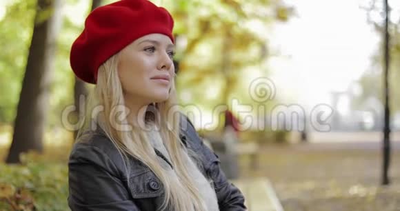 穿红色贝雷帽的女人在长椅上放松视频的预览图