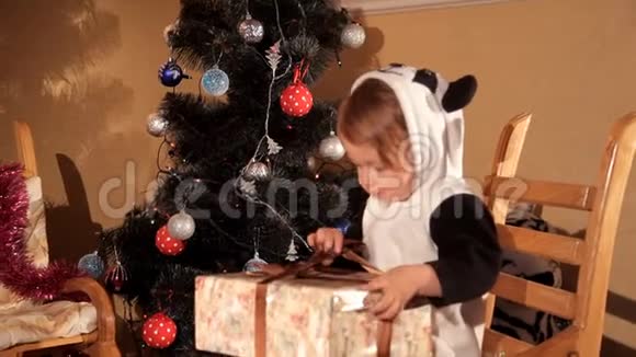 小孩在圣诞树旁打开新年礼物视频的预览图