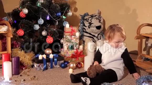 小女孩带着新年礼物在圣诞树旁玩耍视频的预览图