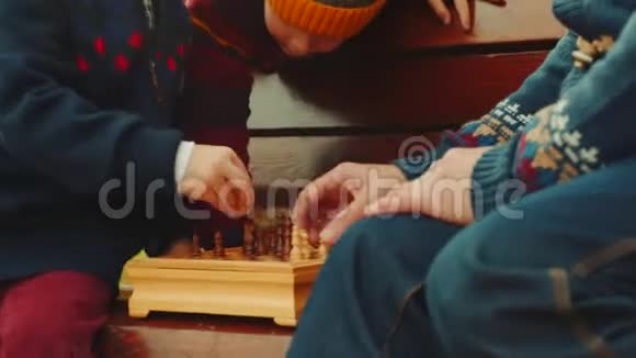 孩子们正在秋天公园的长椅上和爷爷下棋视频的预览图