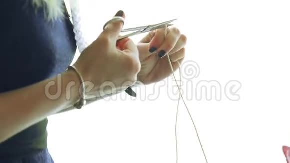 女孩用剪刀剪绳子视频的预览图