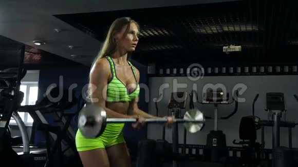美丽的运动肌肉年轻女孩健身女孩训练用杠铃做运动视频的预览图