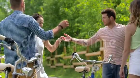 快乐的朋友骑自行车在夏日公园跳舞视频的预览图