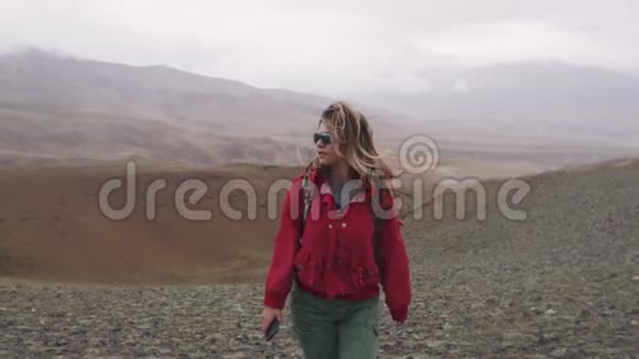 极端情况下的旅行者这个女孩是一个在雨中沿着山区行走的游客视频的预览图