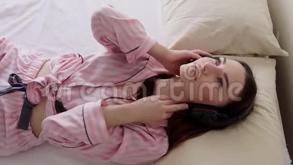 穿着睡衣的美女躺着用耳机听音乐视频的预览图