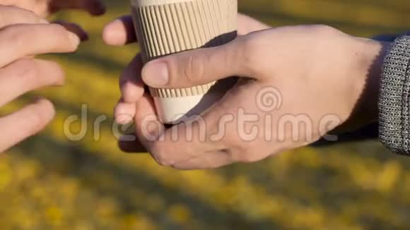 男人在秋天的森林背景下给女朋友喝杯咖啡关心视频的预览图