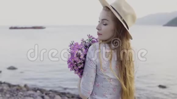 带着鲜花的女孩微笑着在大海的背景下玩得开心视频的预览图