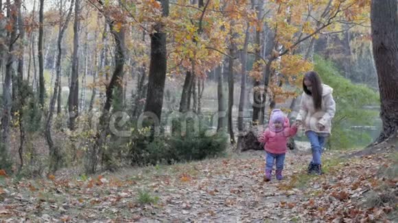 女孩和她的妹妹一起在美丽的公园散步视频的预览图