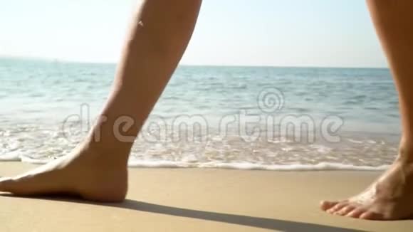 女性的双腿紧贴幸福的女人靠近海浪海洋冲浪热带岛屿慢蛾视频的预览图