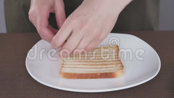 一位妇女正在准备早餐用鳄梨和甜菜根做三明治的手的特写镜头视频的预览图
