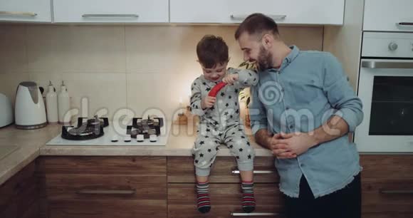 在厨房里爸爸和他的孩子一起玩蔬菜4k视频的预览图