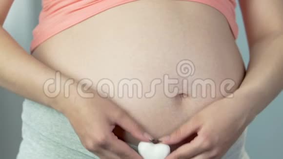 未来的母亲抱着心靠着肚子母爱期待视频的预览图