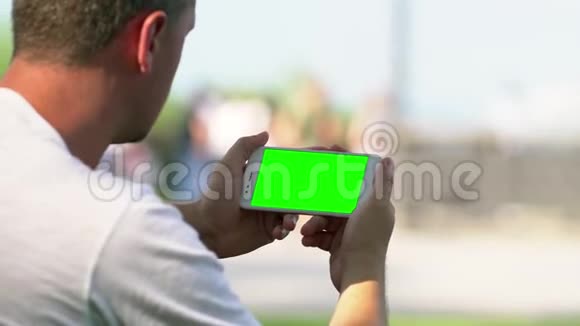 一个男人在一次活动中拿着一部空白的手机视频的预览图