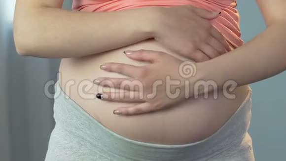 怀孕的女士围着孩子揉胃孕晚期特写视频的预览图