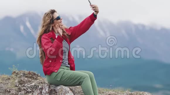 女孩游客在相机智能手机上自拍视频的预览图