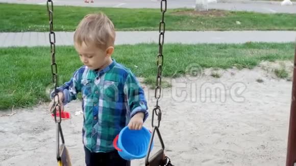 2岁男孩在公园操场上玩沙子的慢镜头视频的预览图