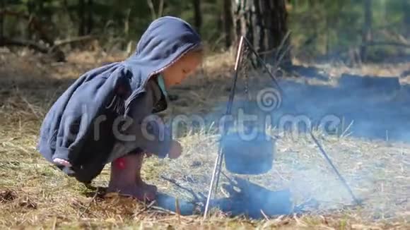一个小女孩在篝火上扔木头独立勤奋视频的预览图