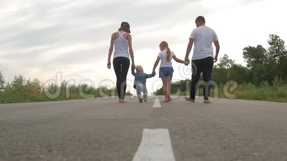 父亲和母亲带着孩子走在乡村的道路上旅行旅游远足和人的概念视频的预览图