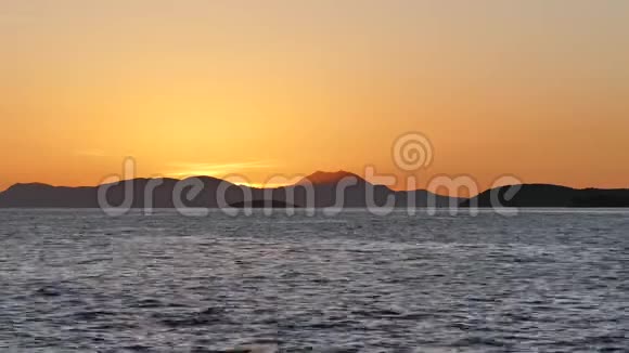 希腊伊古梅尼察海岸山峦上美丽的金色日落视频的预览图