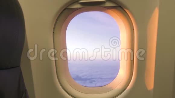 日落时从飞机窗口观看多云的天空天空阴云密布窗外飞舞的美丽风景日出视频的预览图