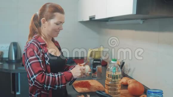 厨房里的女人正在用刀子清洗洋葱女孩做饭在厨房的概念女人在清洗蝴蝶结视频的预览图