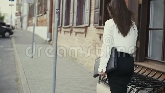 女人在旧城使用智能手机行走慢节奏视频的预览图