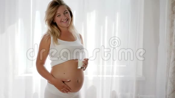 孕期奶制品的营养未来妈妈捧着玻璃牛奶微笑视频的预览图