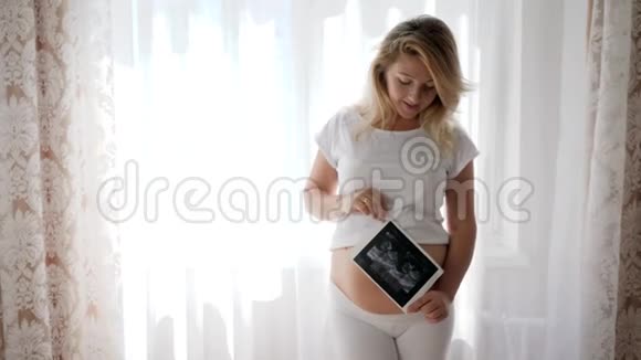 孕妇在镜头前给婴儿做超声波扫描并微笑视频的预览图