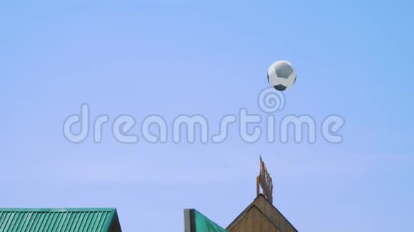 蓝天背景上的足球气球飞过屋顶视频的预览图