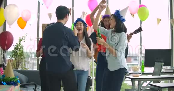 一群年轻人在他们的办公室里跳舞玩得开心用烤面包和叮叮当当的举杯庆祝视频的预览图