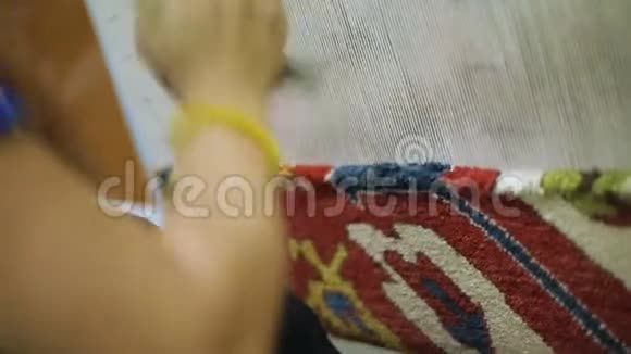 女性编织地毯用剪刀切割编织线传统工艺视频的预览图