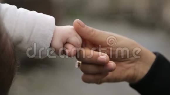 母亲握着婴儿的小手带着温柔和关怀带着母爱视频的预览图