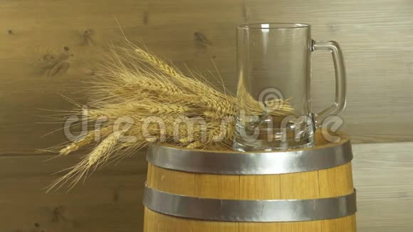 啤酒节啤酒桶和木制桌子上有小麦和啤酒花的玻璃杯视频的预览图
