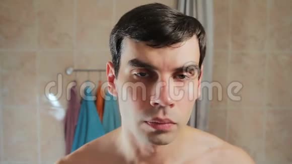一个男人刮胡子后抹脸上的乳液他用了后水后脸会刺痛视频的预览图