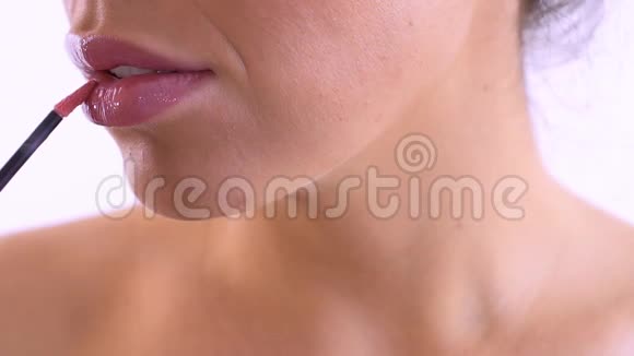 女人用粉红色的唇膏涂上嘴唇视频的预览图
