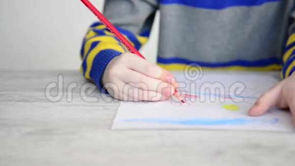 男孩用红色铅笔画画视频的预览图