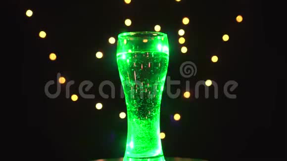 一杯水在五彩的光线下旋转着鸡尾酒迅速变色酒吧概念视频的预览图