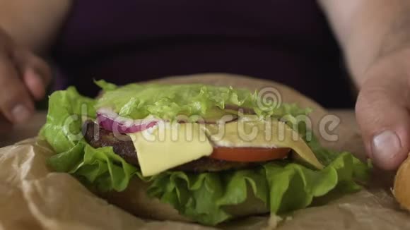 男性精心烹饪芝士汉堡三明治垃圾食品成瘾关闭视频的预览图