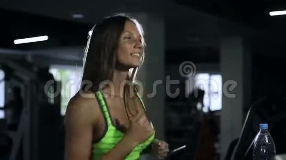 美丽的女孩在健身房跑步机上跑步健康的生活方式理念视频的预览图