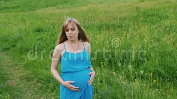 Stadicam射击漂亮的孕妇在乡间小路上行走视频的预览图