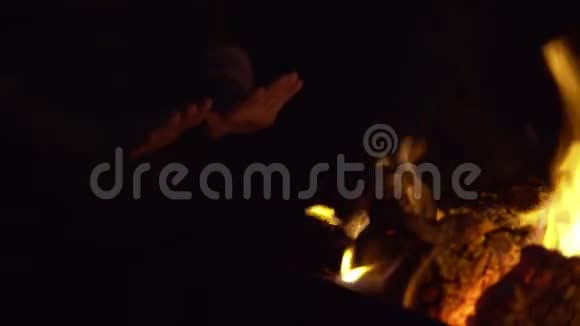 一个面目全非的女人在篝火旁温暖双手视频的预览图