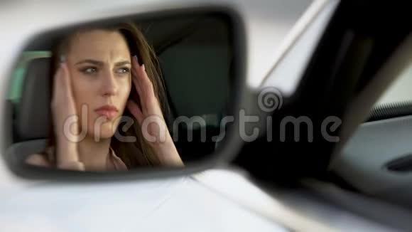 美丽的女人坐在车里头痛得厉害不开心视频的预览图