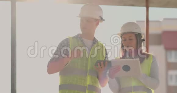 建筑在建筑中有一个女的和一个男的建筑建筑工人工程师沿着它走视频的预览图